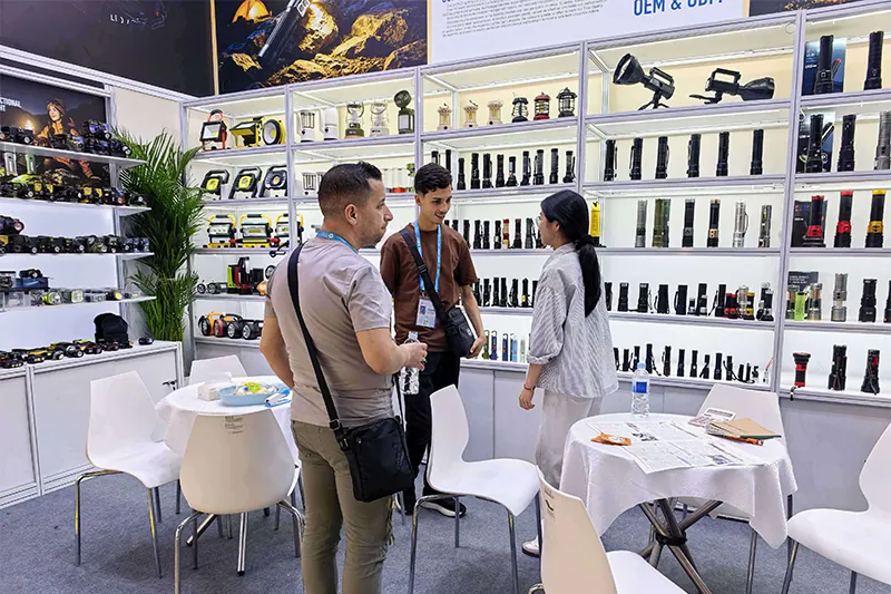 Buyers talking with PLD staff in front of the flashlight wall at China Import and Export Fair (Canton Fair) 2026